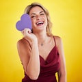 Portrait, paper heart and woman with humor, care and female person against a studio background. Face, lady and happy