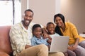 Portrait of parents and children holding laptop while sitting on sofa Royalty Free Stock Photo