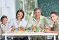 Portrait of parents and children playing with colorful plastic blocks at classroom