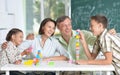 Portrait of parents and children playing with colorful plastic blocks at classroom