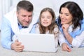 Portrait of parents and daughter using laptop in room Royalty Free Stock Photo