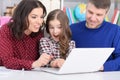 Portrait of parents and daughter using laptop in room Royalty Free Stock Photo