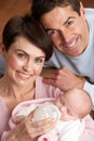 Portrait Of Parents Feeding Newborn Baby At Home