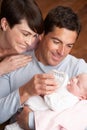 Portrait Of Parents Feeding Newborn Baby At Home