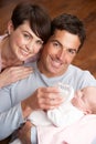 Portrait Of Parents Feeding Newborn Baby At Home