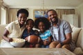 Portrait of parents and kids watching television in living room Royalty Free Stock Photo