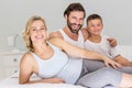 Portrait of parents and son sitting on bed in bedroom Royalty Free Stock Photo