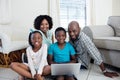 Portrait of parents and their children using laptop in living room Royalty Free Stock Photo