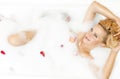 Portrait of Passionate Alluring Sensual Caucasian Blond Resting in Foamy Bathtub Filled with Rose Petals Royalty Free Stock Photo