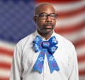 Portrait of a patriotic African american man with glasses and Fourth of July bow tie against American flag backdrop Royalty Free Stock Photo