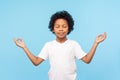 Portrait of peaceful cute little boy holding fingers in mudra gesture and meditating with closed eyes, feeling calm positive