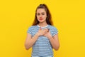 Portrait of peaceful, dear, good young woman holding hands on heart in appreciation, thank you gesture, being touched or flattered Royalty Free Stock Photo