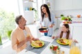 Portrait of peaceful friendly family little girl cheerful parents prepare eat tasty homemade food communicate have good Royalty Free Stock Photo