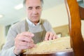 Portrait peaceful senior cabinetmaker repairing old chair