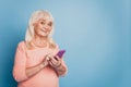 Portrait of pensioner lady use telephone wear pink sweater isolated over blue color background