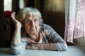 Portrait of a pensioner woman at the table in home