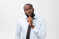 Portrait of a pensive African American businessman in a gray suit thinking with pen on his hand. Royalty Free Stock Photo