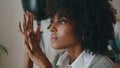 Portrait pensive african woman with curly hairstyle looking at distance indoors. Royalty Free Stock Photo