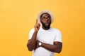 Portrait of a pensive afro american man in glasses looking up at copyspace isolated on a yellow background Royalty Free Stock Photo