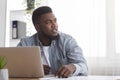 Portrait of pensive afro businessman sitting at workplace in modern office Royalty Free Stock Photo