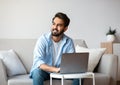 Portrait Of Pensive Arab Freelancer Guy Working With Laptop Computer At Home Royalty Free Stock Photo