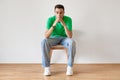 Portrait of pensive arab man sitting on chair at home and thinking about something, suffering life problems Royalty Free Stock Photo