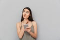 Portrait of a pensive asian woman holding mobile phone