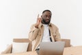 Portrait of a pensive black freelancer sitting at a table in his home office looking for an idea. Thoughtful black man