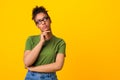 Black woman in glasses thinking about question, touching chin Royalty Free Stock Photo