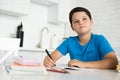 portrait of pensive boy doing homework alone at table Royalty Free Stock Photo
