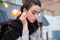 Portrait of pensive brunette girl listening music in wireless earphones