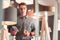 Portrait of pensive focused adult gentleman holding phone in showroom Royalty Free Stock Photo