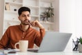 Arab man using laptop sitting at desk in office Royalty Free Stock Photo