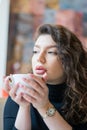 Portrait pensive girl in cafe drinks morning coffee