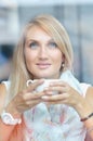 Portrait of a pensive girl drinking coffee and looking outdoors through a window Royalty Free Stock Photo