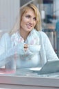 Portrait of a pensive girl drinking coffee and looking outdoors through a window Royalty Free Stock Photo