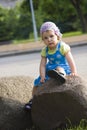 Portrait of pensive girl sitting on a rock