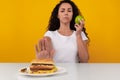 Portrait of Pensive Lady Holding Apple And Burger Royalty Free Stock Photo