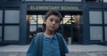 Portrait pensive teen pupil in front modern school entrance. Boy posing outdoors Royalty Free Stock Photo