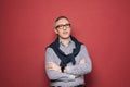 Portrait of pensive mature businessman in light blue and white checked shirt and glasses against red background Royalty Free Stock Photo