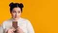 Portrait Of Pensive Obese Girl With Chocolate Bar In Hands