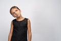 Portrait of pensive pretty girl brunette in a black dress. Beautiful doubtful indecisive child looking up thoughtful