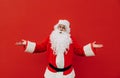 Portrait of a pensive Santa Claus standing on a red background and looking away and thinking. Christmas and New Year Royalty Free Stock Photo