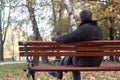 Portrait of a pensive senior man sitting on the bench, in the public park, outdoors Royalty Free Stock Photo