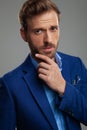 Portrait of pensive smart casual man wearing blue suit