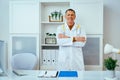 portrait of pensive smiling male doctor physician in lab coat with stethoscope with arms crossed Royalty Free Stock Photo