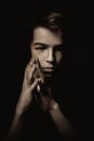 Portrait of pensive teenager on black background