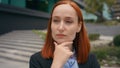 Portrait pensive thinking serious Caucasian ginger hair business woman in city outdoors businesswoman think problem