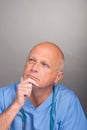 Portrait of pensive / thoughtful doctor, wearing surgical mask and stethoscope. Royalty Free Stock Photo