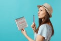 Portrait pensive woman in blue dress, hat holding red pencil, female periods calendar for checking menstruation days Royalty Free Stock Photo